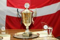 Ein Pokal vor einer dänischen Flagge