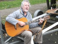 Mann mit Gitarre auf Bootstrailer sitzend