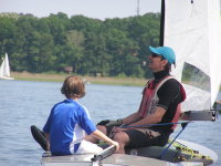 Vater und Sohn genieen auf der Jolle die Sonne